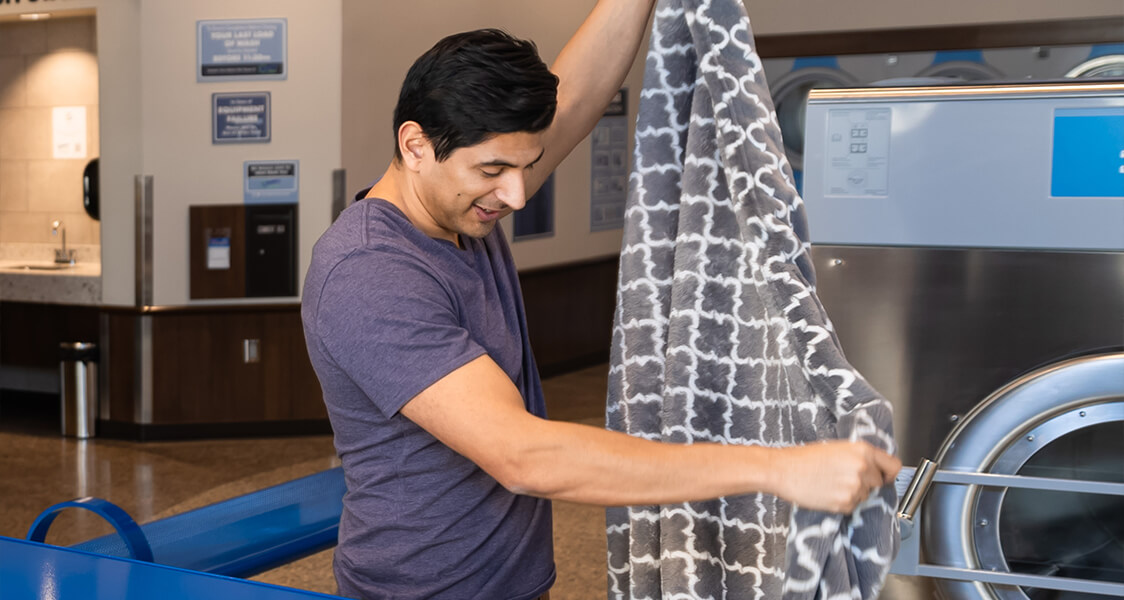 a man folding a clean blanket